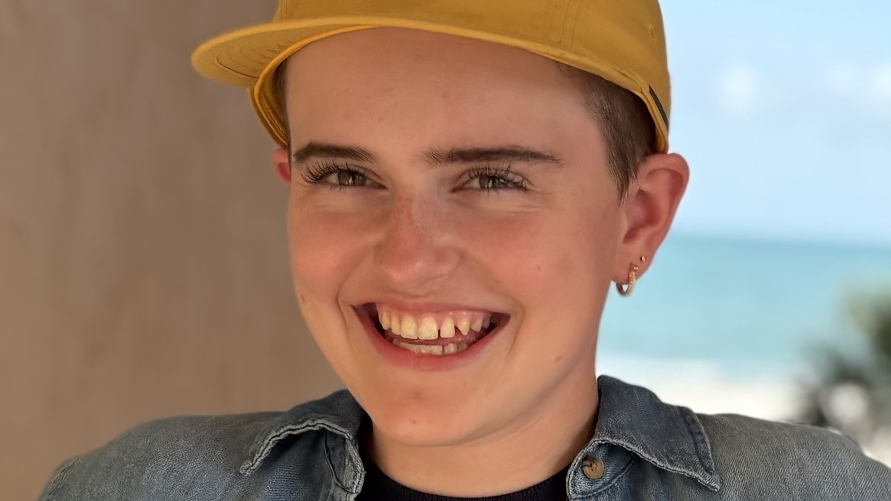Ivy Miller smiles in front of a lakeshore background while wearing a yellow cap and denim jacket Ivy Miller smiles in front of a lakeshore background while wearing a yellow cap and denim jacket